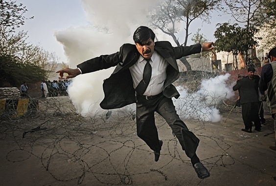 A Pakistani lawyer runs away from tear gas fired by police outside the residence of the country's deposed chief justice, Iftikhar Mahmood Chaudhry, during a protest in Islamabad, Pakistan, on March 9, 2008.