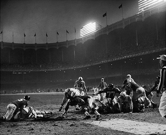 Yankee Stadium, Bronx, NY, December 28, 1958

In 1958, I started going to Yankee Stadium every Sunday for Giants home games. I couldn’t afford a ticket, but I discovered that about an hour before game time, buses from a veterans’ hospital pulled up outside the stadium with forty or fifty veterans in wheelchairs. They always needed people to help wheel the veterans into the stadium. I volunteered, quickly becoming a regular. We would position the wheelchairs up against the center field wall, a few feet behind the end zone. Under my coat, I always had my Yashica-Mat camera. On my sixteenth birthday, December 28, 1958, I found myself standing ten yards directly in front of Alan Ameche as he scored the winning touchdown in that famous “Sudden Death” game. What a wonderful birthday present! -- A picture that even today, fifty-one years later, is unquestionably one of my very best.