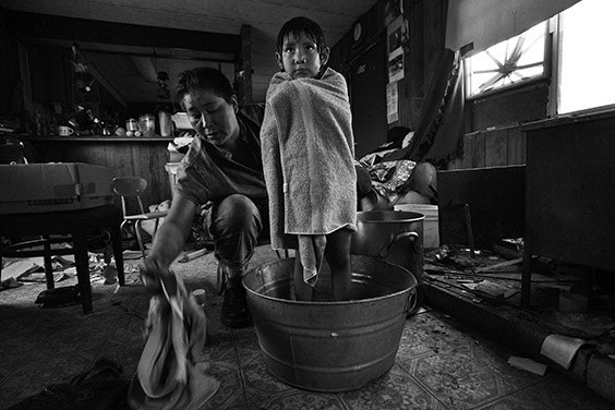 Thomasina Nez, 35, gives Bobbi, 4, a bath in a tin basin in their dilapidated trailer on a Navajo reservation in Cameron, Arizona. Without running water, Nez must bathe her children in water hauled from 30 miles away and heated on the family’s wood stove. The Bennett Freeze ban, lifted officially in March 2009, prohibited some 8,000 Navajos living on 1.5-million acres of disputed land in Arizona from erecting or repairing their homes, including putting in water lines, unless approved by the neighboring Hopi. Consequently, the U.S. Bureau of Indian Affairs says 77 percent of the homes in the area aren’t suitable to live in.