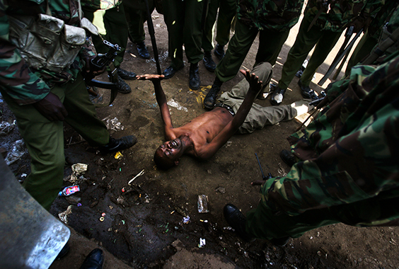 A man lays on the ground after being attacked by Kenyan police during clashes in the Kibera slums on January 17, 2008 in Nairobi, Kenya. Some 600 people have been killed in severe post-election violence amid allegations that the incumbent president manipulated the December elections.