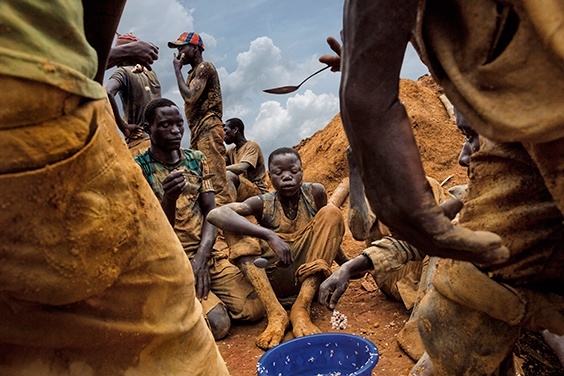 Pluto, Democratic Republic of the Congo, 2013
Miners eat lunch from a communal bowl in the mining town of Pluto in Ituri Province. They work here to extract rock and sand from a large pit that has taken over a year to excavate. The miners are made up of many different people from all over Congo who come to seek their fortune.