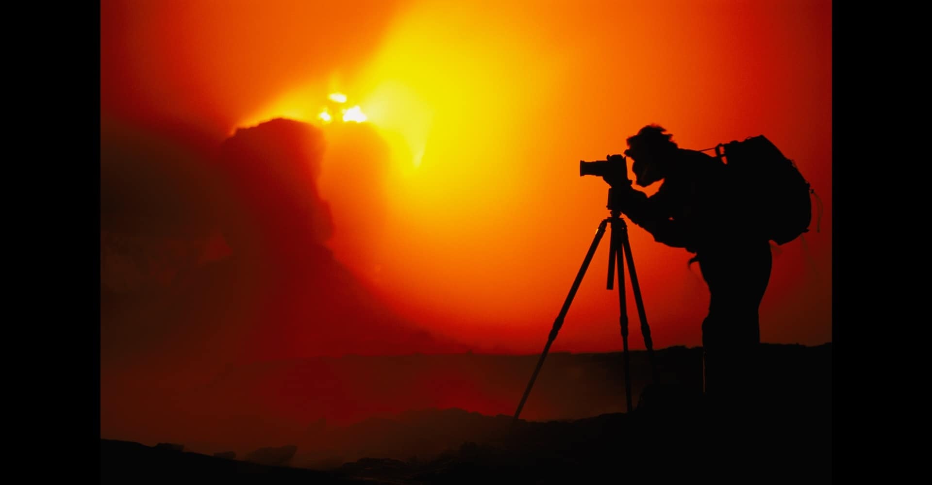 Frans Lanting photographing an erupting volcano, Hawaii