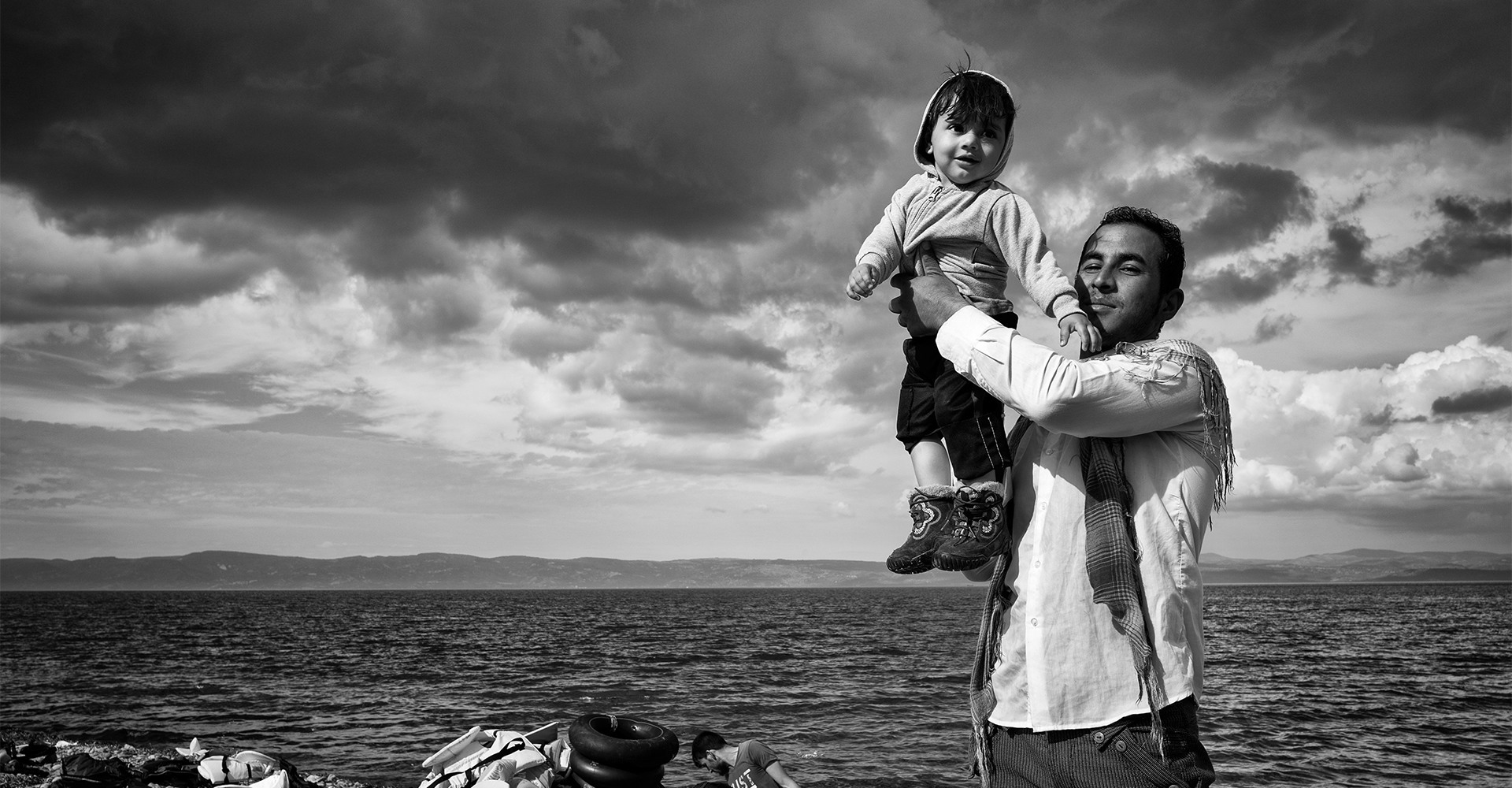 Lesbos, Greece, October 2015: A father celebrates with his child on the Greek island of Lesbos after a stormy crossing with his family over the Aegean Sea from Turkey. 